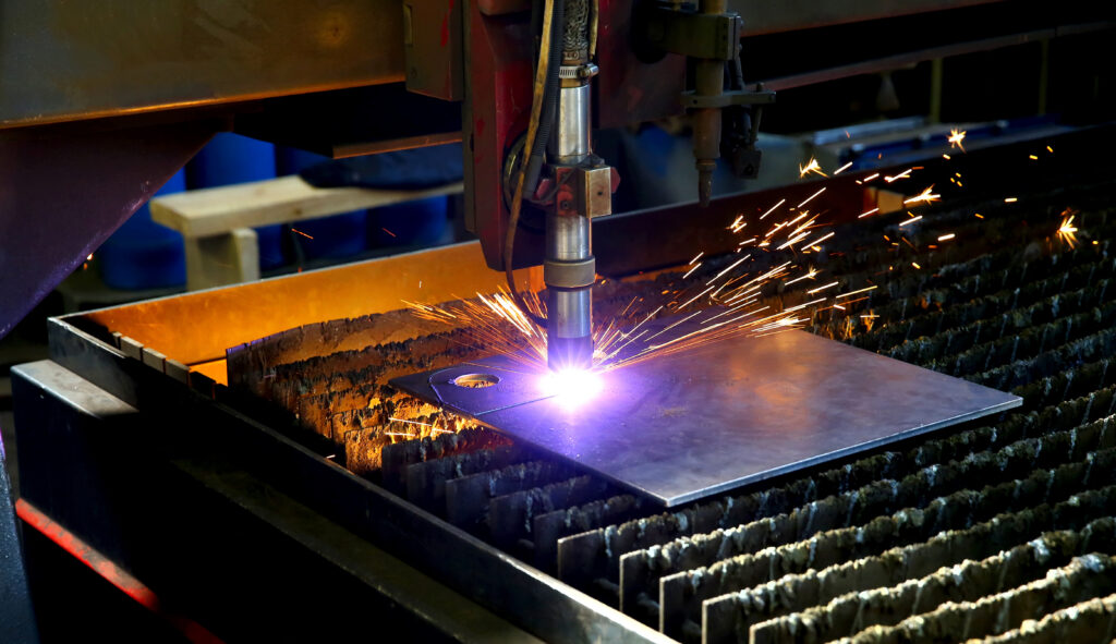 Máquina de corte por láser en operación, cortando una lámina de metal con precisión industrial y generando chispas